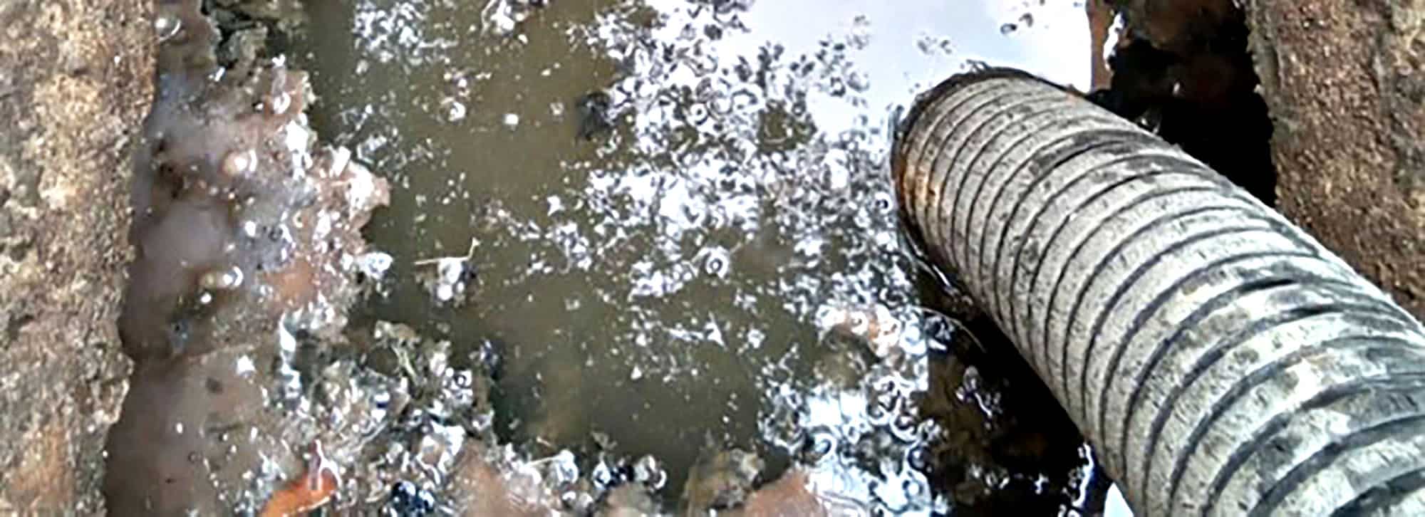 Industrial hose extracting wastewater from a muddy area