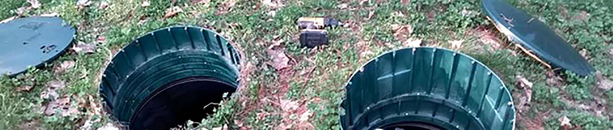 Open septic tank lids on a grassy ground