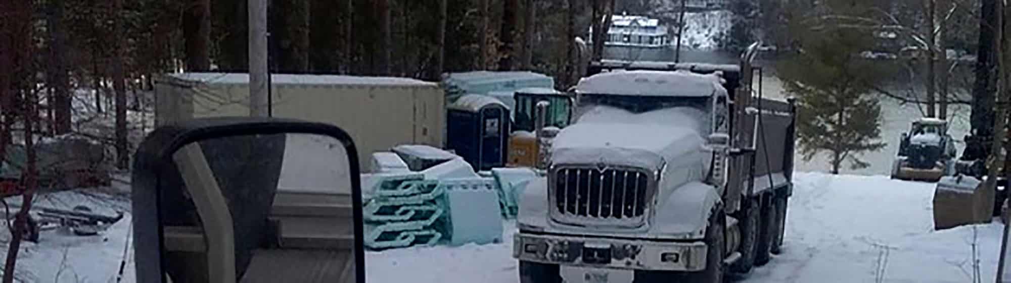 Snow-covered truck and construction site in winter forest
