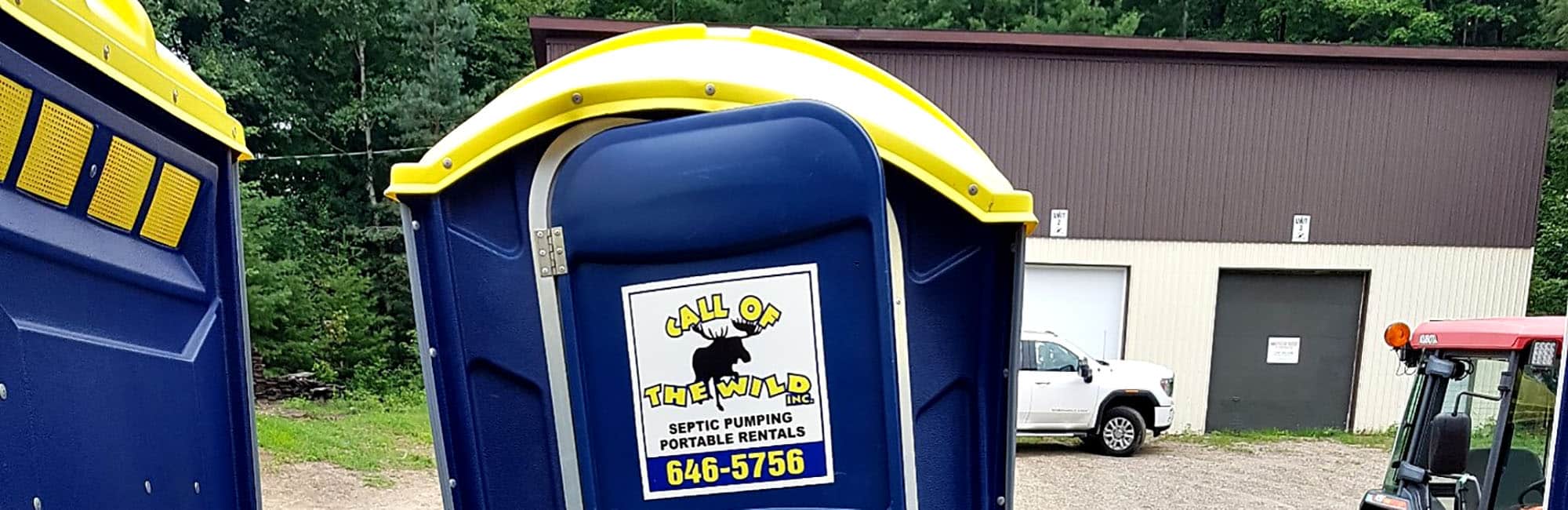 Portable toilet with company logo in an outdoor setting
