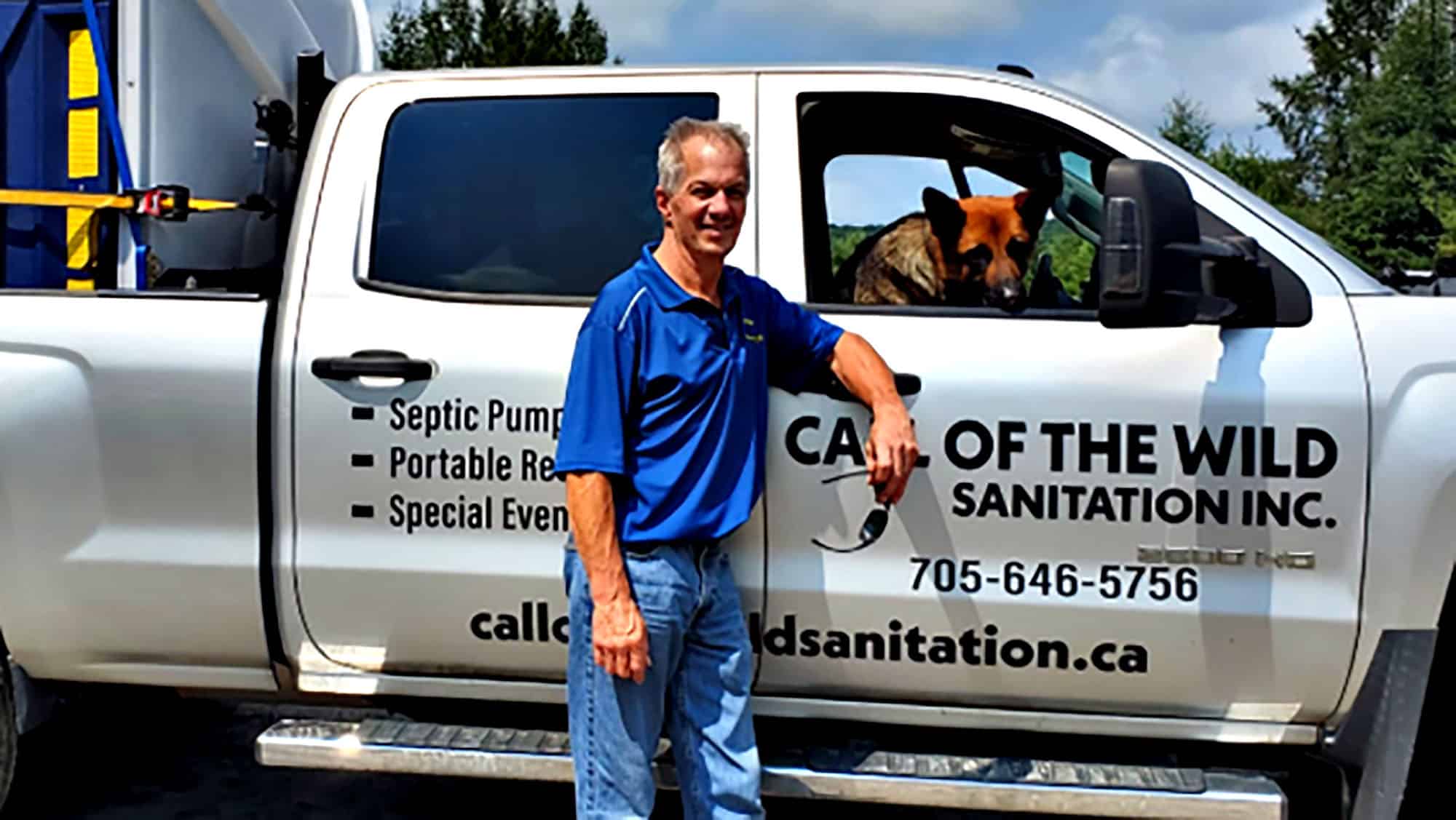 Sanitation service truck with worker and German Shepherd inside
