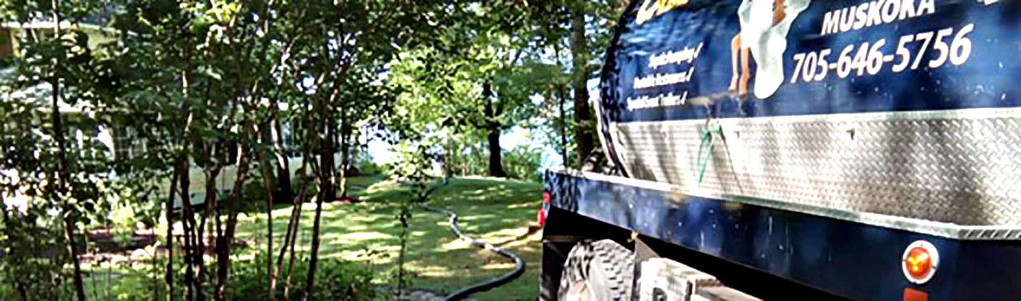 Septic service truck in Muskoka, Ontario near a lakefront property
