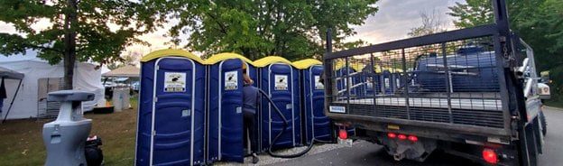 Portable toilets being cleaned at an outdoor event