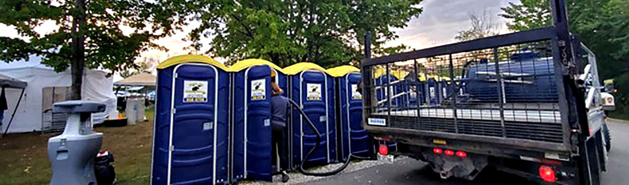 Service worker maintaining portable toilets at an outdoor event