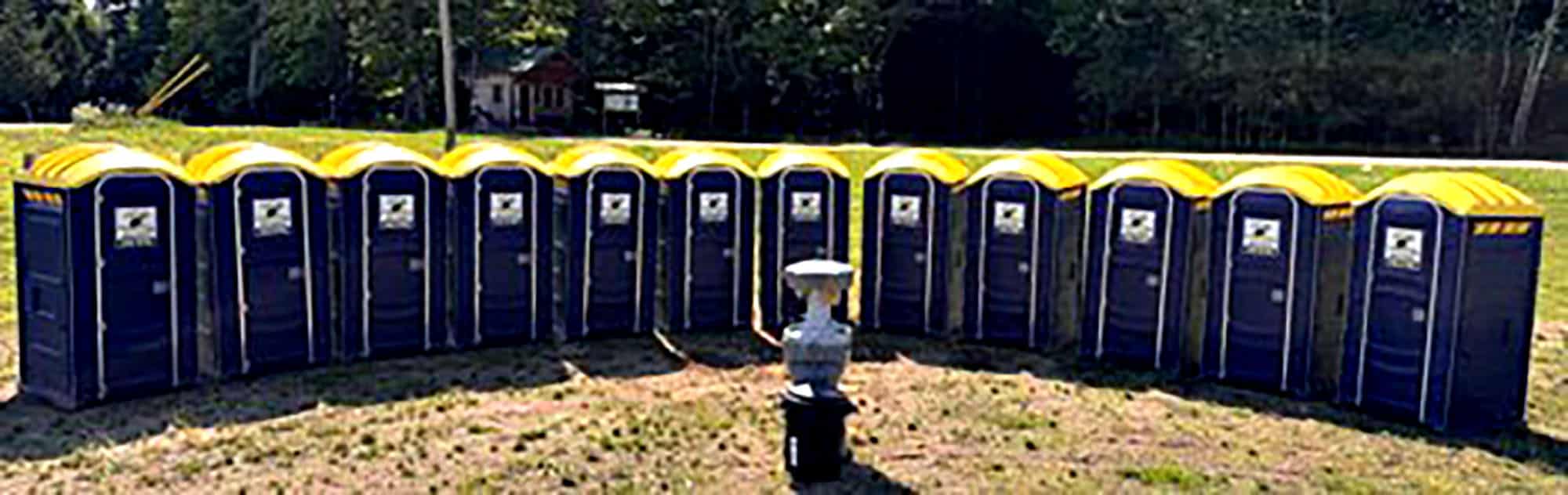 Circle of portable toilets with sculpture in centre outdoors