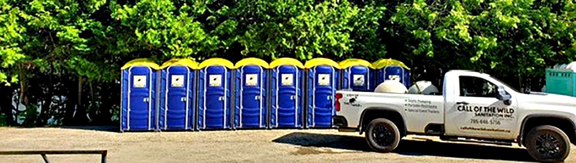 Portable toilets and company truck in outdoor location