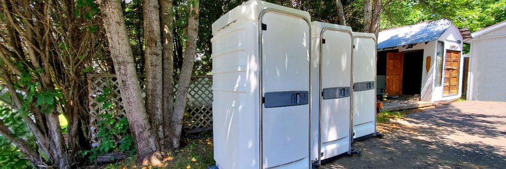 Portable toilets in a wooded outdoor area