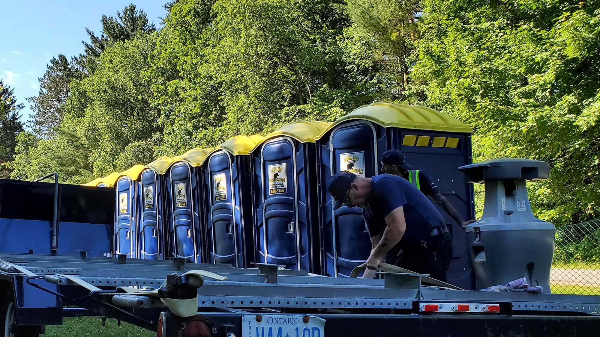 Portable toilets being unloaded at an Ontario outdoor event site